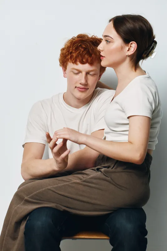 Couple of young man and woman with casual clothes in studio, close affectionate pose, relationship and intimacy, relaxed moment with trust and connection between people.