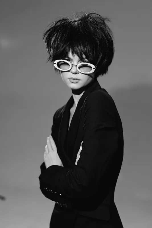 stylish woman wearing sunglasses in black and white portrait with short hair and dark blazer