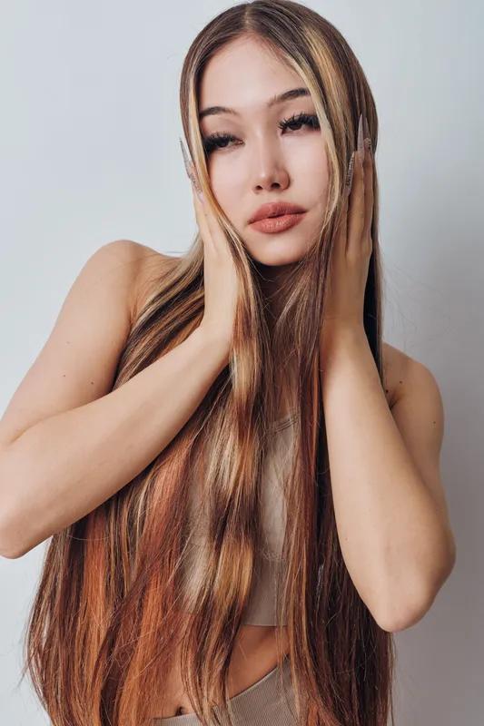 Woman with long straight hair posing with hands near face, natural makeup and neutral background. Beauty, fashion, portrait and hairstyle concept with female model.