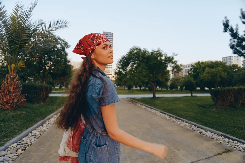 lifestyle woman in modern boho-western denim street style walking outdoors, film color, casual fashion, relaxed mood, sunny day, natural background