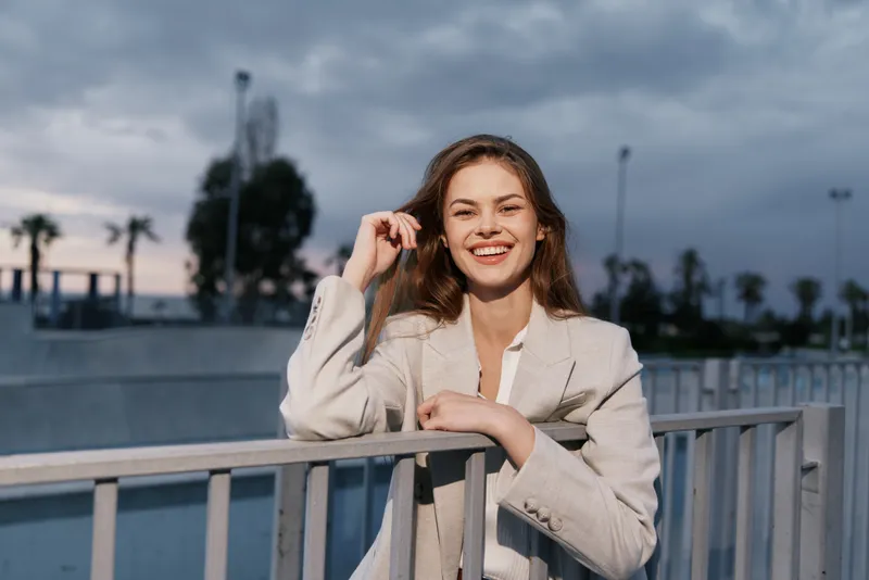 young woman smiling in beige blazer outdoor casual fashion portrait urban background
