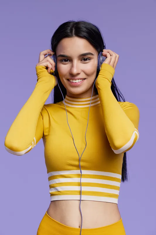Young woman sport fitness wearing yellow activewear smiling with headphones, preparing for workout, healthy lifestyle and positive energy concept.