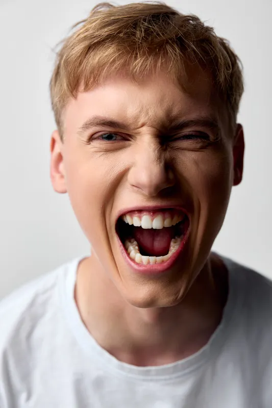 Scream, shouting, anger, expression, close up, male, youth, energy, emotion, mouth open in a loud yell, capturing raw intensity, dynamic facial moment, bold mood for urgency, drama or expressive