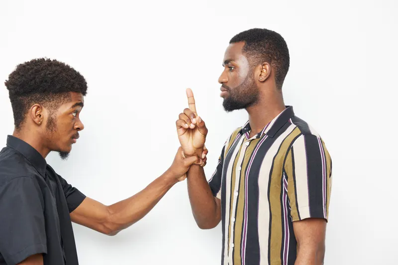 Two African American men having an intense conversation, showcasing various emotions. Tension, expression, and body language come together in this engaging moment.