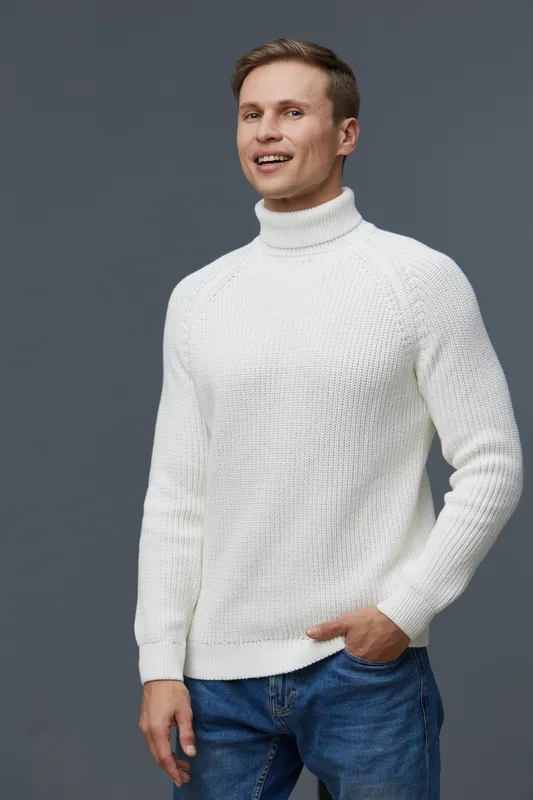Happy young man with short brown hair, wearing a white turtleneck sweater and blue jeans, smiling and looking at the camera, hand in pocket, isolated on plain gray background, studio portrait. People 