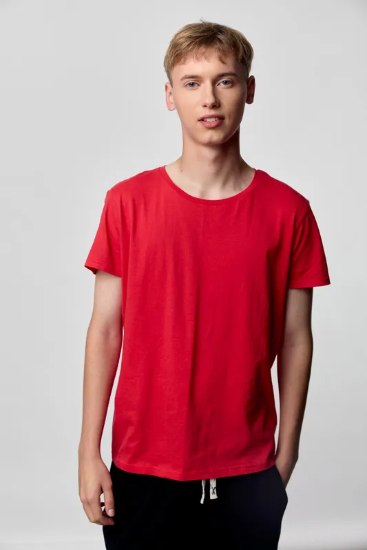 Red shirt worn by a young man in casual clothing, studio shot with a relaxed pose and neutral background, highlighting everyday fashion and comfortable style for lifestyle and apparel catalogs