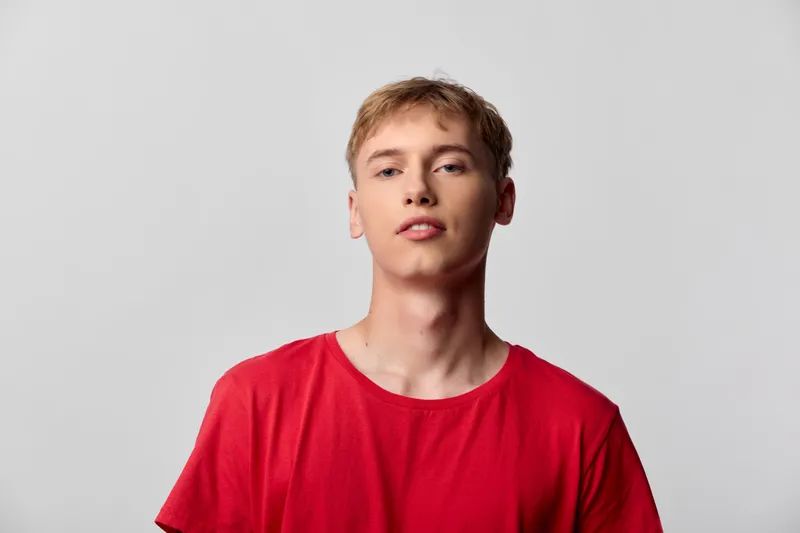 Youth, man, red shirt, studio pose, front view, casual style, plain backdrop, confident look for fashion and lifestyle photography, clean lighting, minimal distractions, versatile model for catalogs