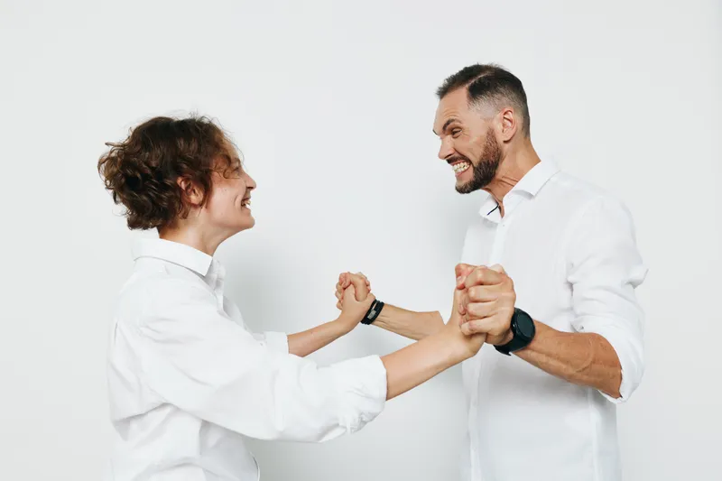 A professional business scene with two men in white shirts sharing a friendly fist bump against an isolated white background, conveying teamwork, confidence, and positive emotion in a modern