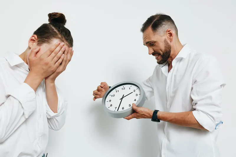 A professional businessman stands against an isolated colored background, showing urgency and emotional tension as he checks the time, conveying focus, pressure, and decision making.