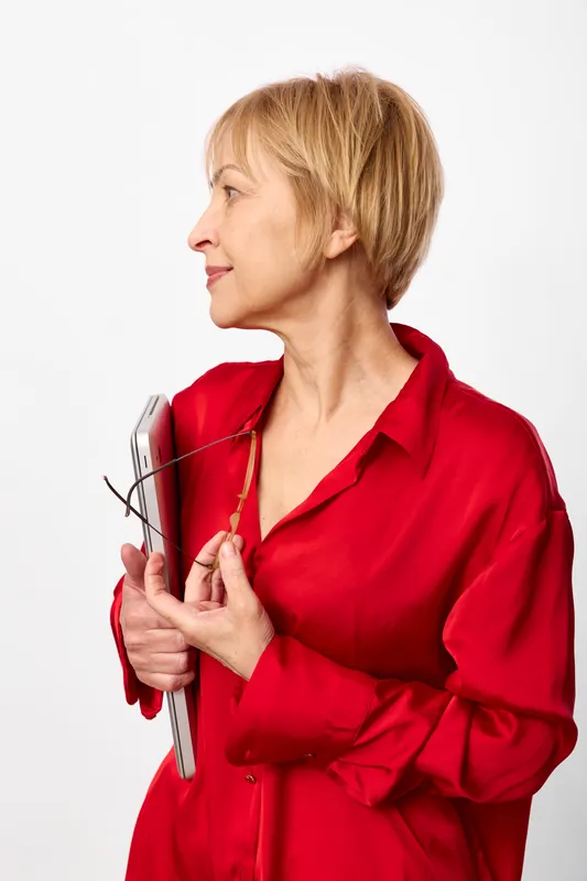 Veterinarian female holding cat, wearing red medical coat, calm portrait on white background, showing attentive pet care and trust, professional copy space