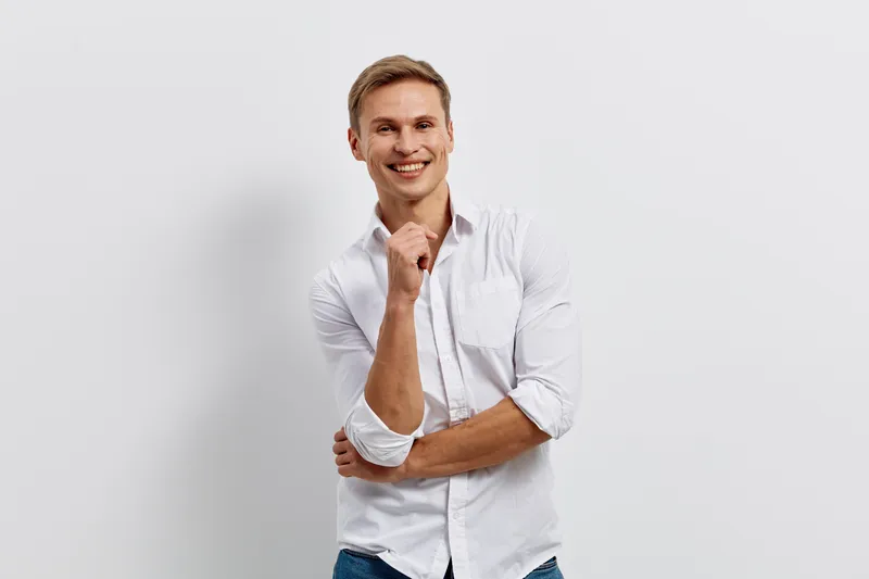 smiling man cybersecurity casual white shirt standing studio gray background looking confident joyful positive emotion lifestyle technology concept
