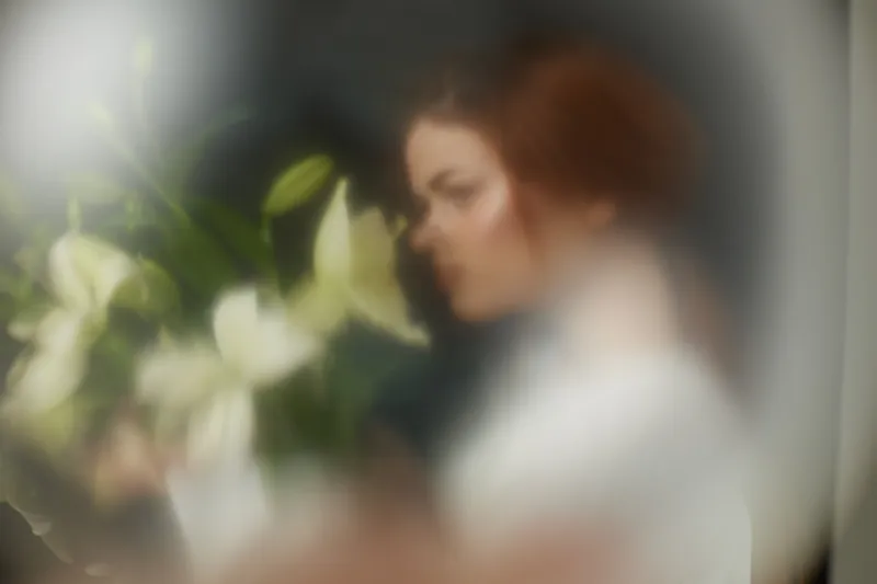 A soft focus portrait of a young woman holding white lilies, conveying serenity and introspection, ideal for wellness and nature themes