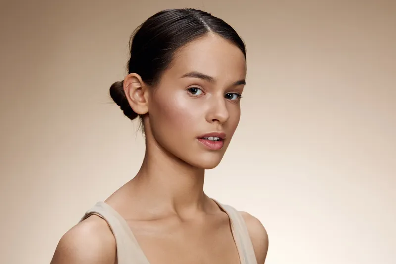 Portrait of a young woman with a natural look and subtle makeup, showcasing healthy skin and a calm expression, perfect for beauty and wellness concepts