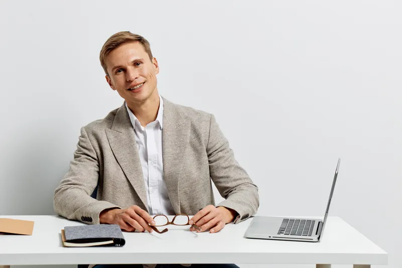 young man working laptop business casual shirt blazer smart office table digital nomad concept technology communication