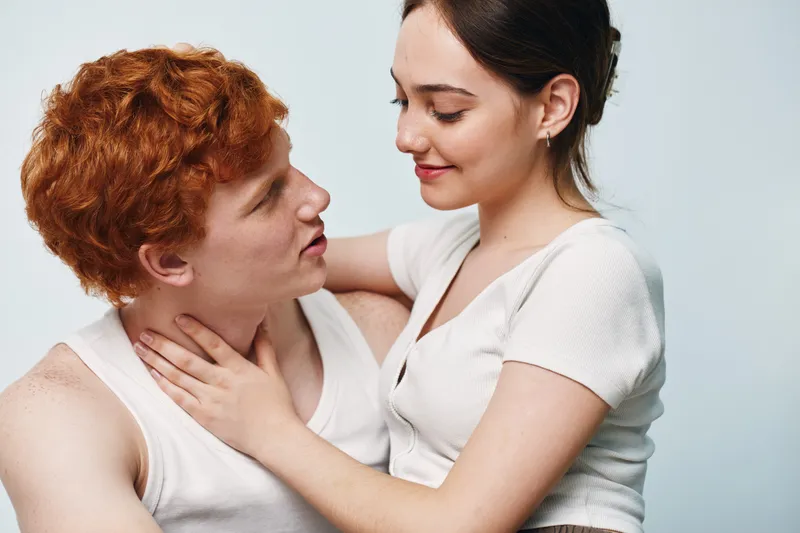 Couple with affectionate expressions in casual clothes looking at each other, romance and intimacy with close connection between young man and woman.