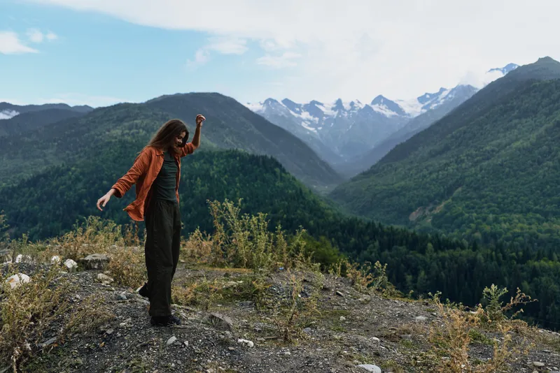 Mountain hiker in nature on rugged landscape, person standing on ridge with solitude and wilderness around, journey and freedom captured in wide view, authenticity inclusivity