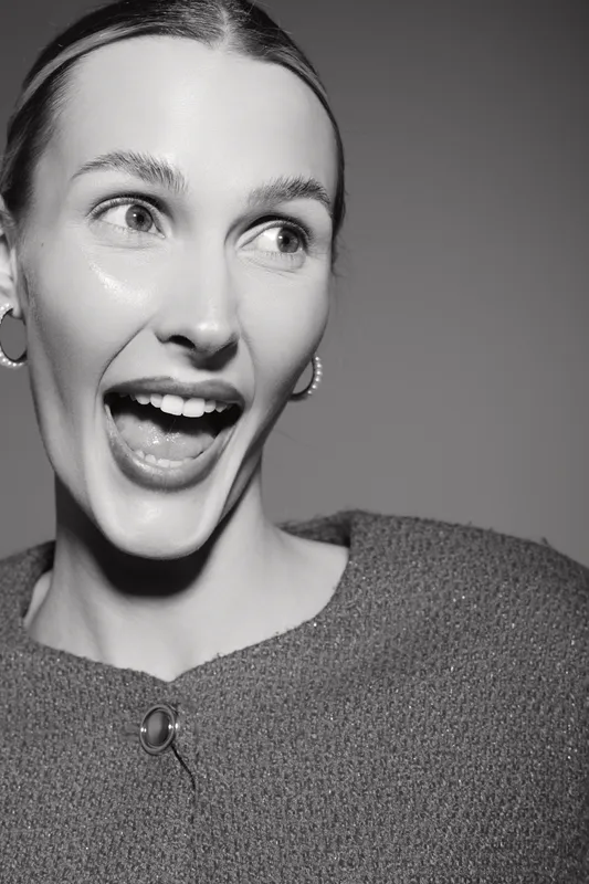 Happy Caucasian woman with fair skin laughs joyfully looking sideways in studio. Concept of positive emotion and natural beauty.