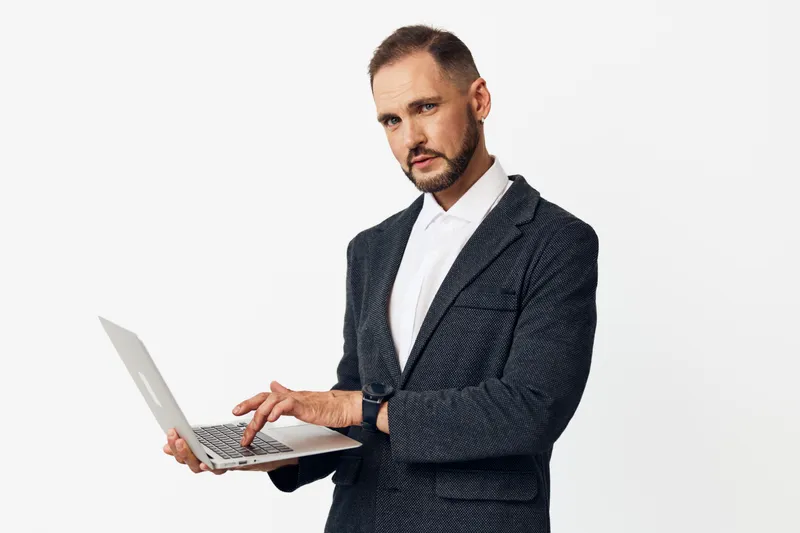 Business professional man on an isolated colored background, focused on keyboard, calm expression, confident demeanor, and strong presence in a modern corporate setting.