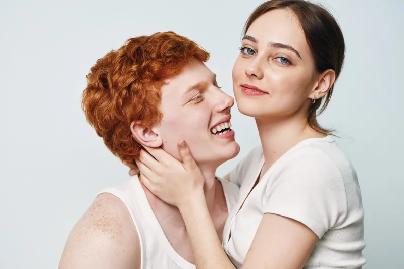 Couple, young man and woman together smiling with affection and happiness, closeup portrait on white background. Relationship, love and connection between two people in casual clothes.