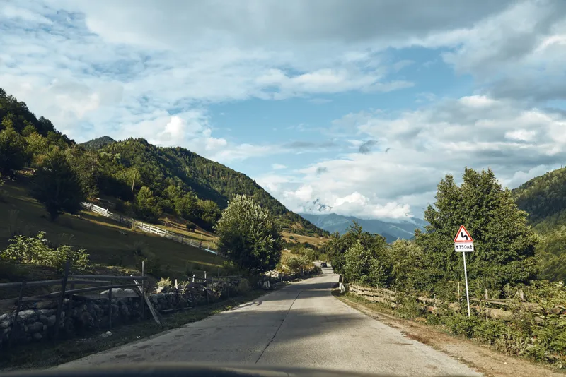 Road mountain landscape rural trees sky clouds nature, peaceful scene authenticity inclusivity