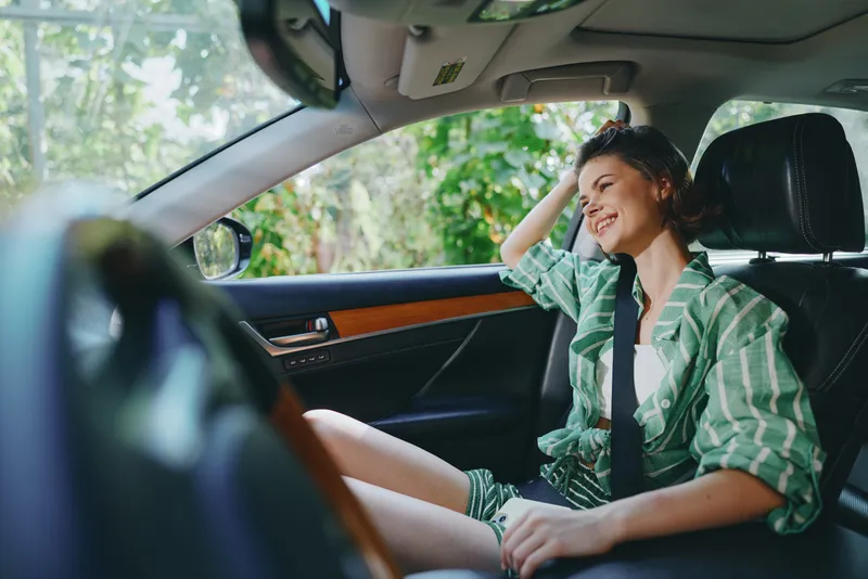 Car, driver, woman, smile a cheerful woman sits comfortably in the driver's seat with her hand on the steering wheel, radiating joy and readiness for a bright journey