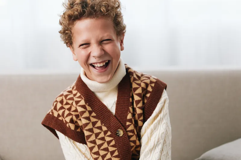 An authentic scene of a playful student in a casual school setting, capturing spontaneous laughter and genuine emotion that define everyday life, learning, and growth.