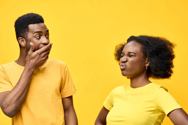 A couple expressing playful emotions against a vibrant yellow background, showcasing dynamic interactions and diverse expressions in matching yellow outfits