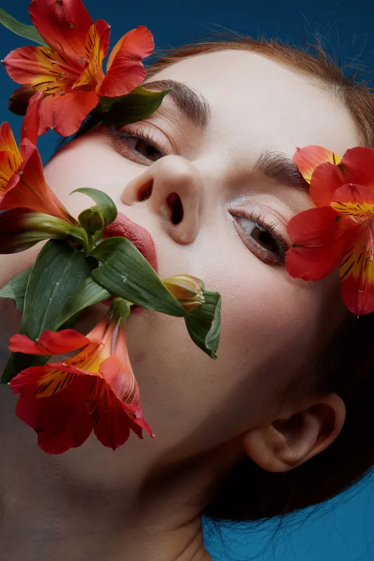 Close up portrait of a young woman with flowers, conveying beauty and nature, featuring vibrant colors, emotion, and a conceptual focus on floral aesthetics
