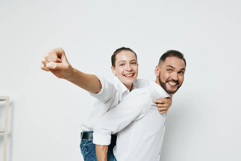 A business professional duo shares a confident, joyful moment against an isolated colorful background, emphasizing teamwork, leadership, and positive emotion in a corporate setting.