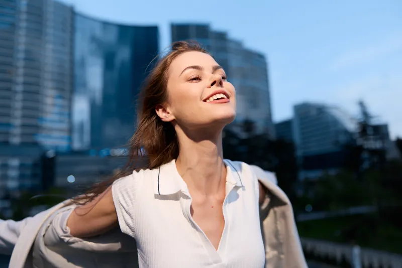 happy woman enjoying freedom and success in urban business environment with modern buildings and dynamic mood