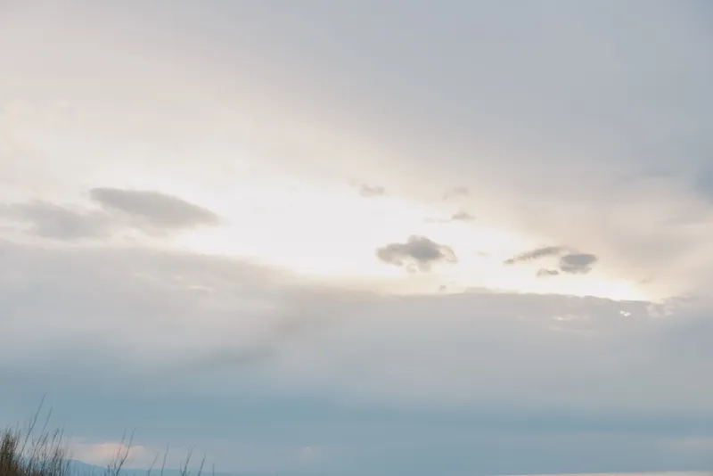 Calm sky with soft clouds during sunset over a natural landscape. Peaceful atmosphere with gentle light and subtle colors creating a serene outdoor scene.