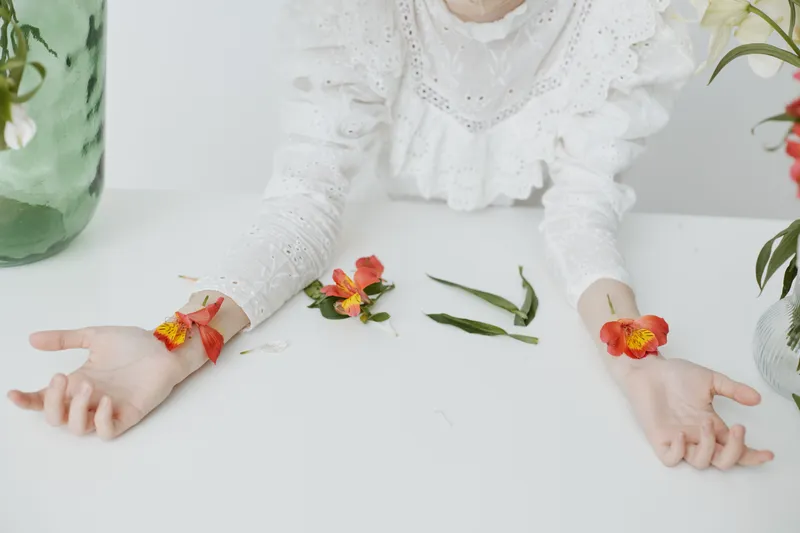 Delicate female hands adorned with colorful flowers, showcasing a fresh and vibrant style, perfect for spring themed designs and wellness concepts
