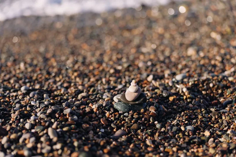 Coast pebbles cairn stone shore nature scene with a small stack on a quiet beach textured surface calm mood and natural detail capturing patience balance and meditative outdoor scenery
