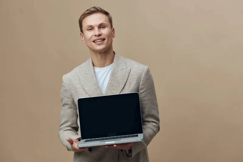 smiling young caucasian man hold laptop wear beige blazer white t-shirt stand isolated neutral background digital nomad work concept