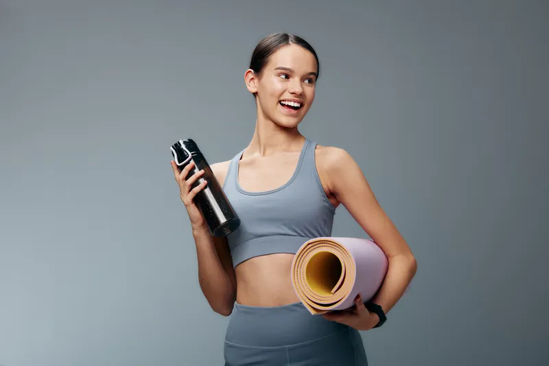 Fitness, woman and sport scene with a yoga mat and shaker bottle, showcasing gym training, healthy lifestyle and energetic workout ready for progress and growth.