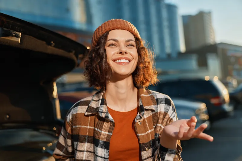 Woman smile portrait in urban setting at golden hour sunlight, candid lifestyle and authenticity captured with mindful living vibe, emotional storytelling and warm city aesthetic.