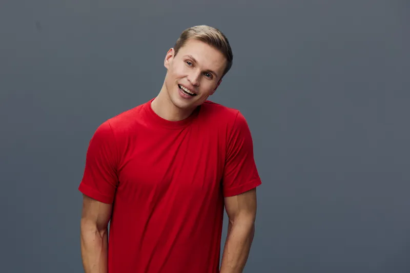 smiling young man red t-shirt studio portrait casual cheerful positive emotion isolated grey background digital detox mental health concept