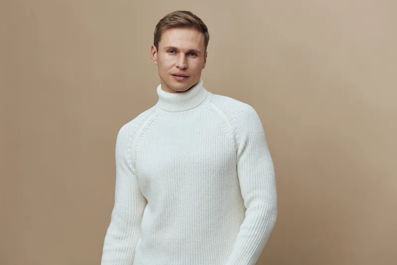 handsome young man wear white knitted turtleneck sweater look camera casual studio portrait winter fashion concept mental health and gadgets
