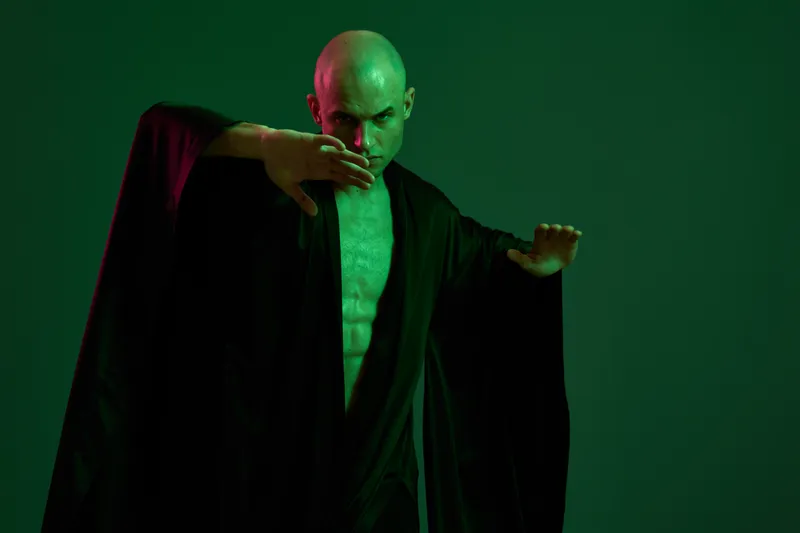 Powerful man in dramatic pose, showcasing strength and determination with abstract green lighting. This striking image captures a captivating moment of confidence.