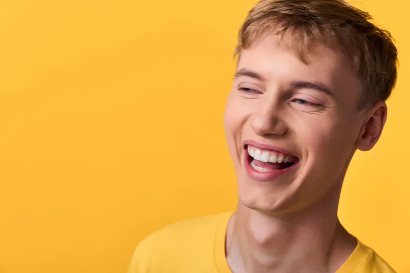 Smiling man with a bright expression against a vivid yellow background wearing a casual yellow tee, conveying joy, positivity and friendly energy for lifestyle, wellness and optimistic branding