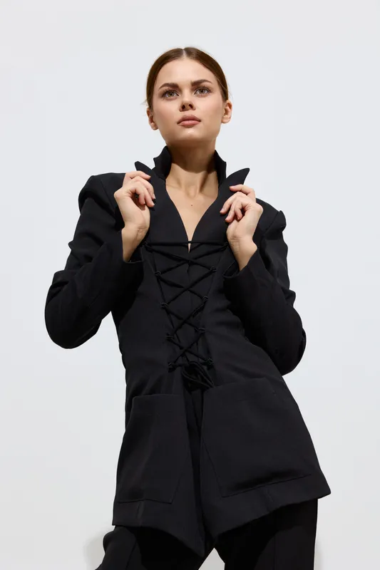 fashion woman in black stylish coat posing confidently against white background, showcasing modern beauty and minimalistic design in high fashion photography