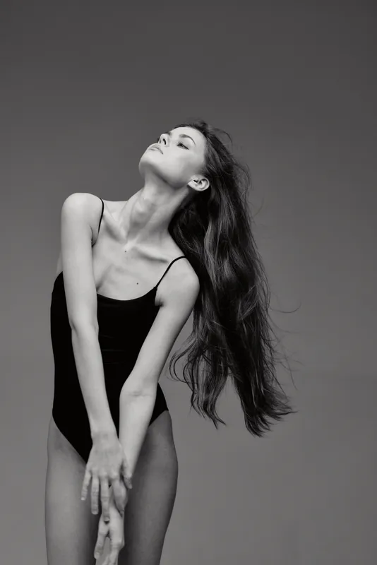 graceful woman in black leotard posing with closed eyes black and white artistic photo