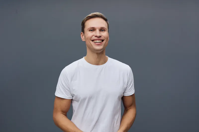 Smiling happy young caucasian man wear casual white t-shirt stand isolated on grey background digital detox concept mental health and gadgets