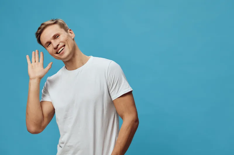 smiling caucasian man wave hand wear white t-shirt blue background casual look friendly gesture digital detox mental health concept