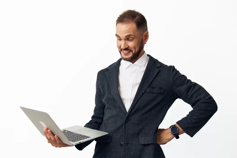 A business professional man smiles while holding a laptop, portraying enthusiasm and confidence. Isolated colored background highlights a bold, energetic mood for corporate branding.