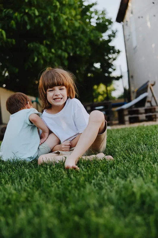 Playful children enjoying a sunny day in the garden, embodying the joy of childhood with laughter and vibrant outdoor surroundings.