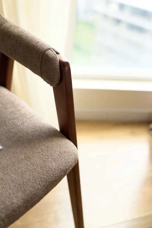 Chair armchair upholstery wood seat window interior fabric in soft natural light, closeup of brown wooden dining chair with textile cover, parquet floor and minimalist home decor.