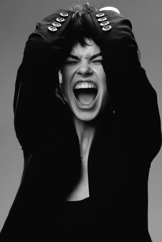 screaming woman expressing frustration in black and white portrait with dramatic lighting and intense emotion