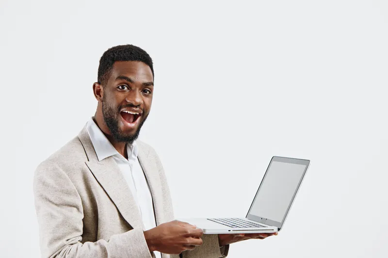 Confident smiling man in beige blazer holding open laptop computer isolated on plain white background studio portrait. Business technology professional lifestyle concept