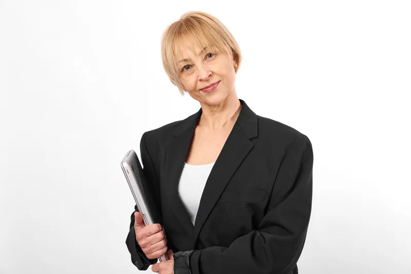 Senior woman holding a smartphone, studio portrait on white background, gentle smile, business clothing, focused eyes, communication and technology, clean minimal soft light